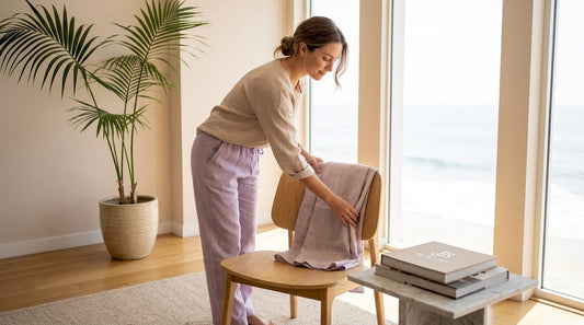 Woman folding linen cover up in bright living room