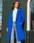 Serena Double Breasted Trench Coat - Electric Blue, front medium view against green wall - Be Juliet