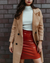 Be Juliet Berlin Rock ‘n’ Roll Vinyl Skirt rust-red, close-up torso against brick wall, glossy sheen